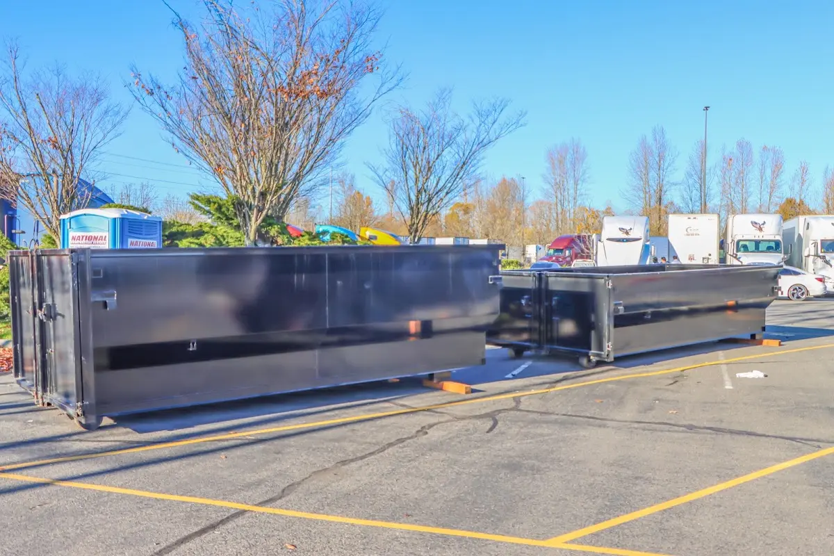 Professional dumpster rental service with roll-off container on residential driveway in East Longmeadow